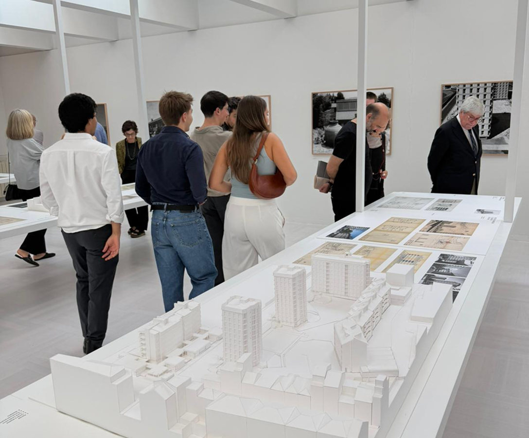 Visitantes junto às maquetes e desenhos expostos